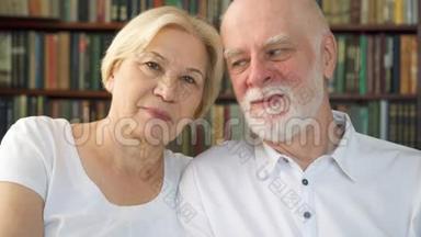 在家里坐在沙发上的开朗好看的老夫妇的肖像。 好好放松一下。